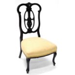An Edwardian mahogany nursing chair, with a pierced carved back, padded seat on cabriole legs.