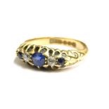 An 18ct gold sapphire and diamond set gypsy ring, set with three sapphires and two diamonds, in a cl