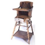 A late 19thC beech wingback child's high chair, upholstered in brown simulated leather fabric, with