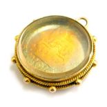 A George IV silver gilt sixpence, in a yellow metal frame.