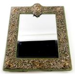 A rectangular white metal mounted dressing mirror, possibly American, decorated overall with flowers