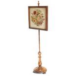 A Victorian rosewood pole screen, the rectangular banner embroidered in raised woolwork with flowers