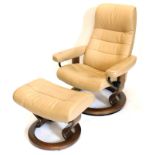 A Stressless beige leather swivel armchair, on laminated circular base, and a matching stool (AF).