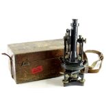 An early 20thC metal cased microscope, with cylindrical centre on an articulated stand, terminating