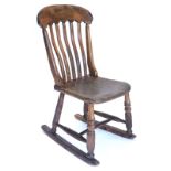 A 19thC lathe back Windsor type kitchen rocking chair, with an elm seat, on turned tapering legs and