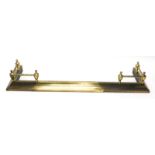 A brass adjustable fire kerb, with a turned rail and tapering base, 127cm enclosed.