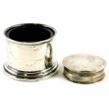 A late Victorian circular silver pill box, with a beaded border, and a plain silver salt with blue g