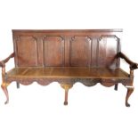 An 18thC oak settle, with a panelled back, a solid seat, on cabriole legs with pad feet, previously