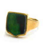 An 18ct gold agate set shield shaped signet ring, with green shield shaped agate in rub over setting