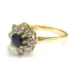 An 18ct gold sapphire and diamond cluster ring, set with round brilliant cut sapphire to centre, sur