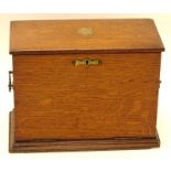 An Edwardian oak desk tidy, of rectangular form, the hinged lid with articulated front, revealing a