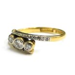 An 18ct gold and platinum set dress ring, of twist design with diamond set shoulders and three illus