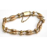 A gate bracelet, of two row design, with lozenge and ball links, on safety chain, rose gold coloured