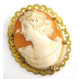 A 9ct gold framed shell cameo brooch, with oval cameo depicting maiden looking left, in scroll desig