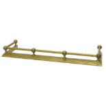 An Edwardian brass fire kerb, with a tubular rail, moulded tapering base, 109cm wide.