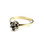 A 9ct gold floral cluster ring, set with blue and white stones, in a small design ring head, ring si