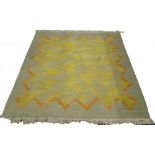 A South African flatweave rug, with a yellow/ green shaded centre and an orange band, 193cm x 196cm.