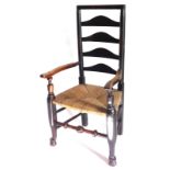A 19thC ash and elm ladder back armchair, with shaped arms and a rush seat, on part turned legs with