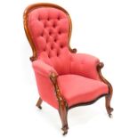 A Victorian mahogany show frame armchair, upholstered in red patterned fabric, with a button back, p