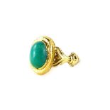 A turquoise set dress ring, with oval cut stone, in a gold hatched rub over setting, with V splayed