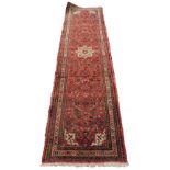 A Persian style runner, with an all over geometric design on a red ground, one wide and two narrow b