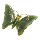 A jade set butterfly brooch, with two jade wings, body and eyes, on a gold plated frame, 4cm wide.