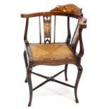 An Edwardian mahogany and marquetry corner chair, with a drop in rush seat, on cabriole legs.