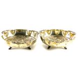 A pair continental white metal dishes, each decorated centrally with a flower head, leaves, etc., th