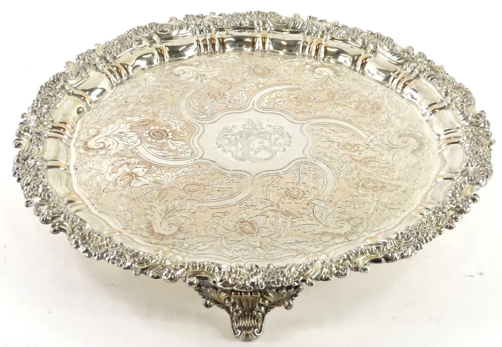 A large silver plated salver, engraved centrally with an elaborate armorial within shell and scroll