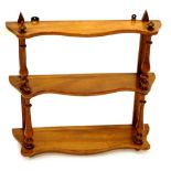 A Victorian walnut wall shelf, with three shaped tiers, on turned supports, 61.5cm wide.