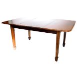 An early 20thC mahogany extending dining table, the rectangular top with a moulded on square taperin