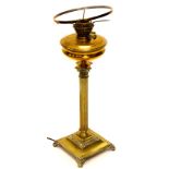 An early 20thC brass oil lamp, with wide circular reservoir on a reeded stem and stepped foot, termi