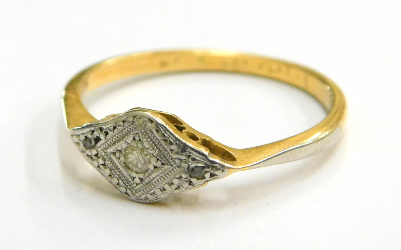 An Art Deco 18ct gold and platinum ring, the ring head in a marquise shape set with three tiny diamo