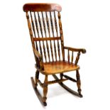 A 19thC spindle back ash and elm rocking chair, with a solid seat on turned supports with later rock