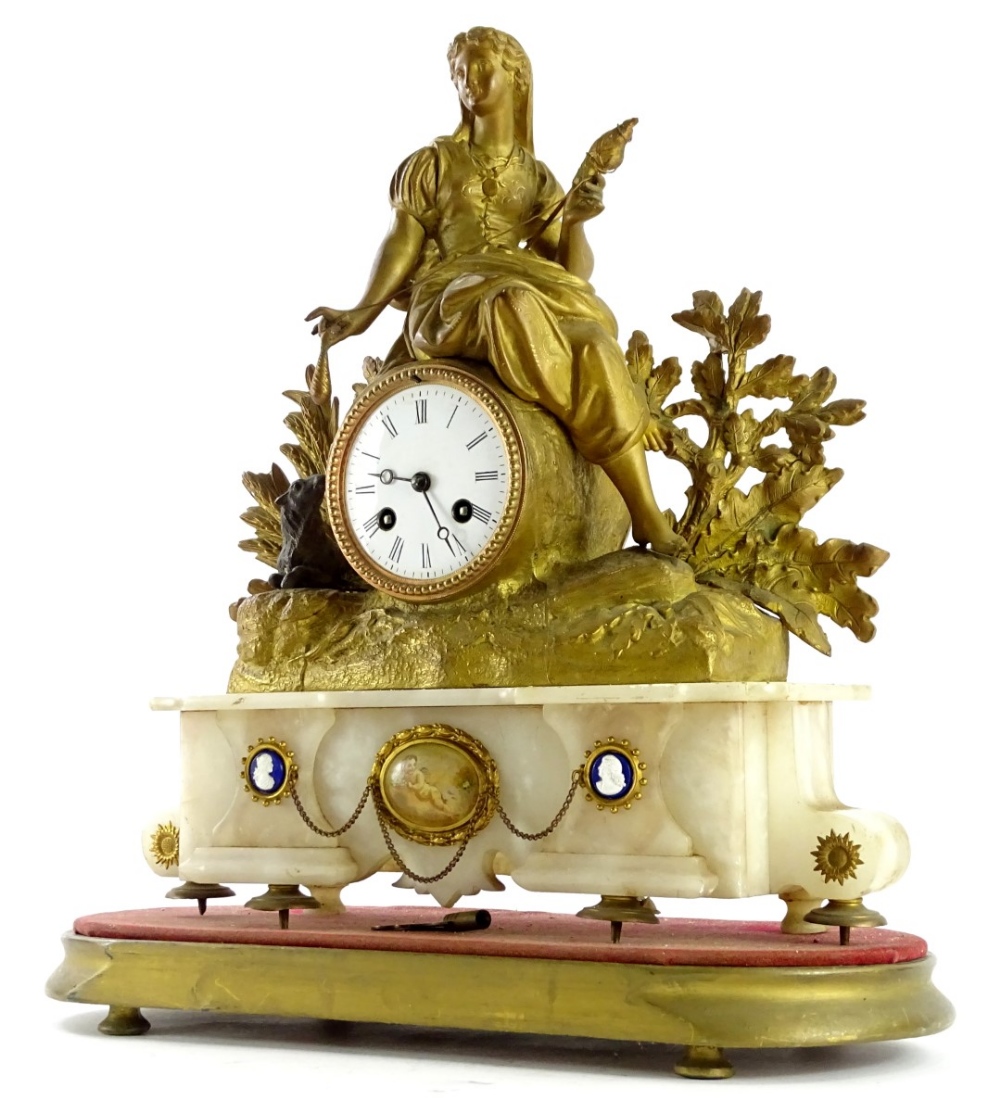 A late 19thC gilt metal mantel clock, the 8cm diameter Roman numeric dial surmounted by a figure of