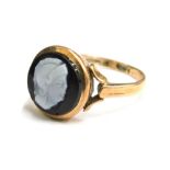 A cameo set dress ring, with small circular ring head set with black cameo with raised white figure