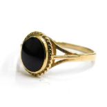 A 9ct gold dress ring, set with polished black stone, with twist design borders and V splayed should