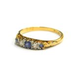 An 18ct gold sapphire and diamond ring, set with three pale blue sapphires and two diamonds, each in