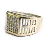 A silver dress ring, with pave set central white stone design and pierced design shoulders, ring siz