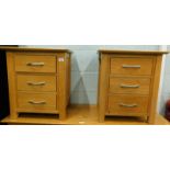 A pair of oak three drawer bedside tables.