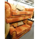 A pair of two seater sofas, in orange and red colour way.