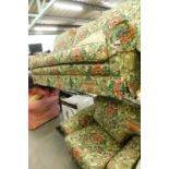 A three seater sofa, and matching armchair, in multicoloured floral fabric.