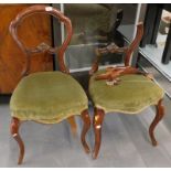 A pair of Victorian mahogany balloon back chairs, each with a green upholstered padded seat on cabri