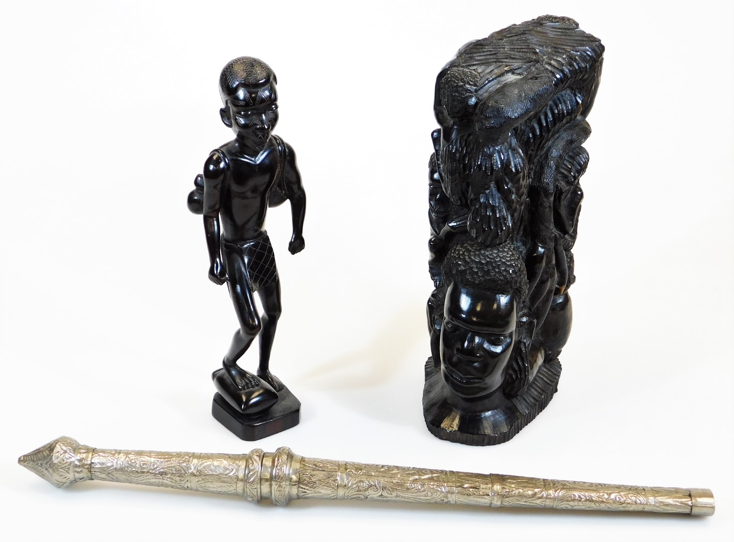 A heavily carved African tribal style figure, with foot raised on a canted base, unmarked, 32cm