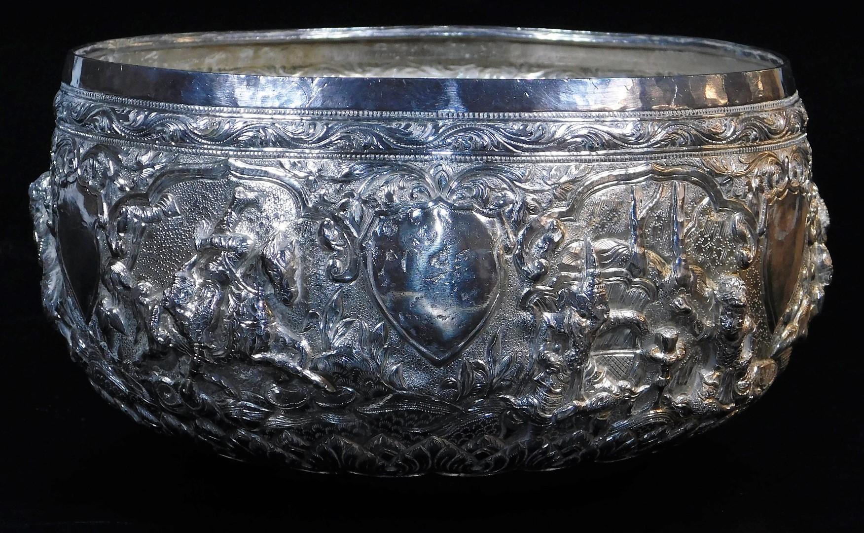 An early 20thC Indian ceremonial bowl, heavily repousse decorated with figures scrolls and