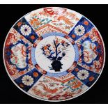 A Japanese porcelain Imari charger, decorated in typical red, orange, green and underglaze blue