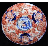 A Japanese porcelain Imari charger, decorated in typical red, orange, green and underglaze blue