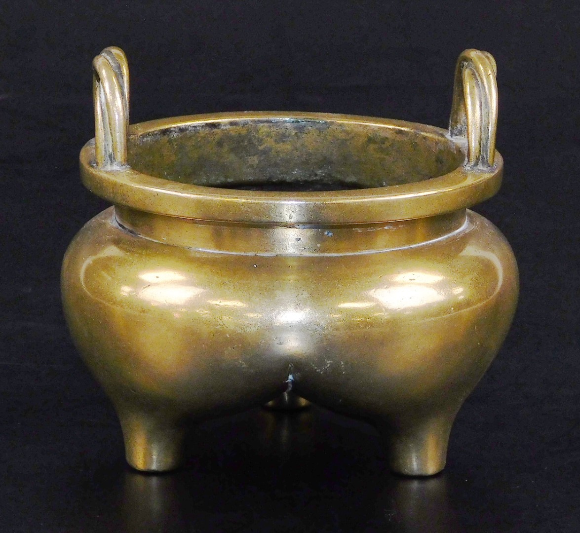 A Chinese bronze tripod censer, with bulbous body and twisted loop handles, six character Xuande