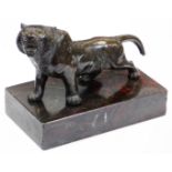 A Japanese bronze model of a snarling tiger, the body with stripes in low relief, associated base,