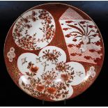 A Japanese porcelain Kutani charger, decorated in red and orange with shaped panels of birds and